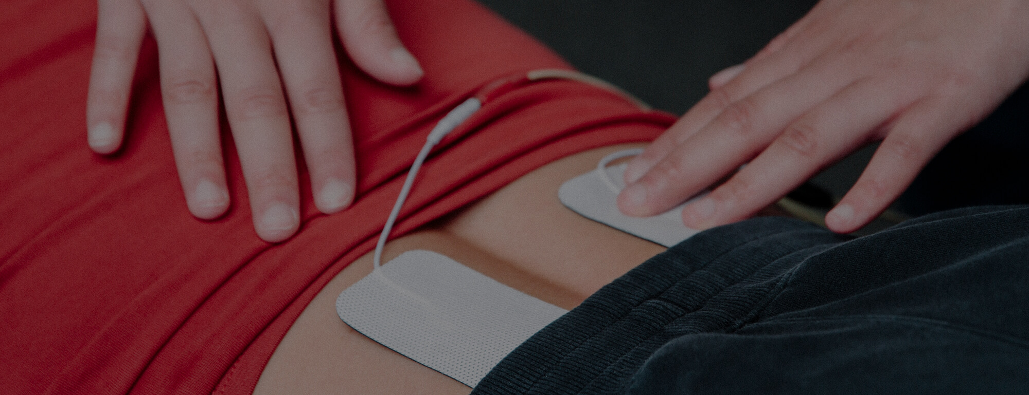 Day Chiropractic staff administering electrical muscle stimulation on the lower back of a patient.