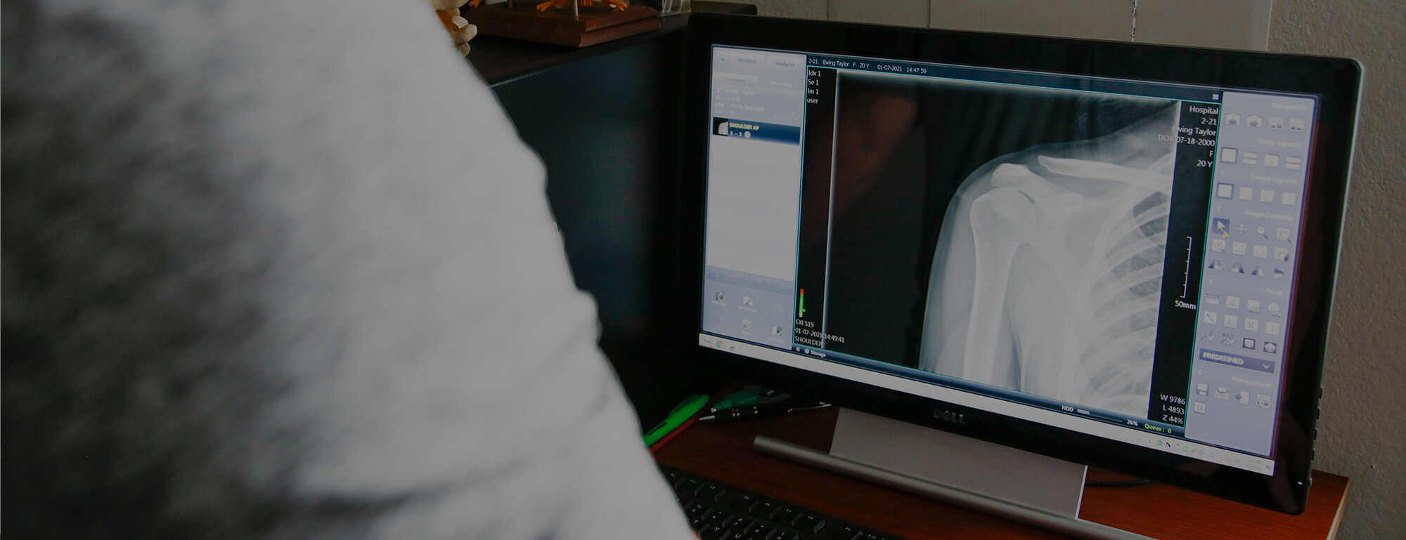 A Day Chiropractic doctor reviews x-ray and imaging for a patient on a desktop screen.